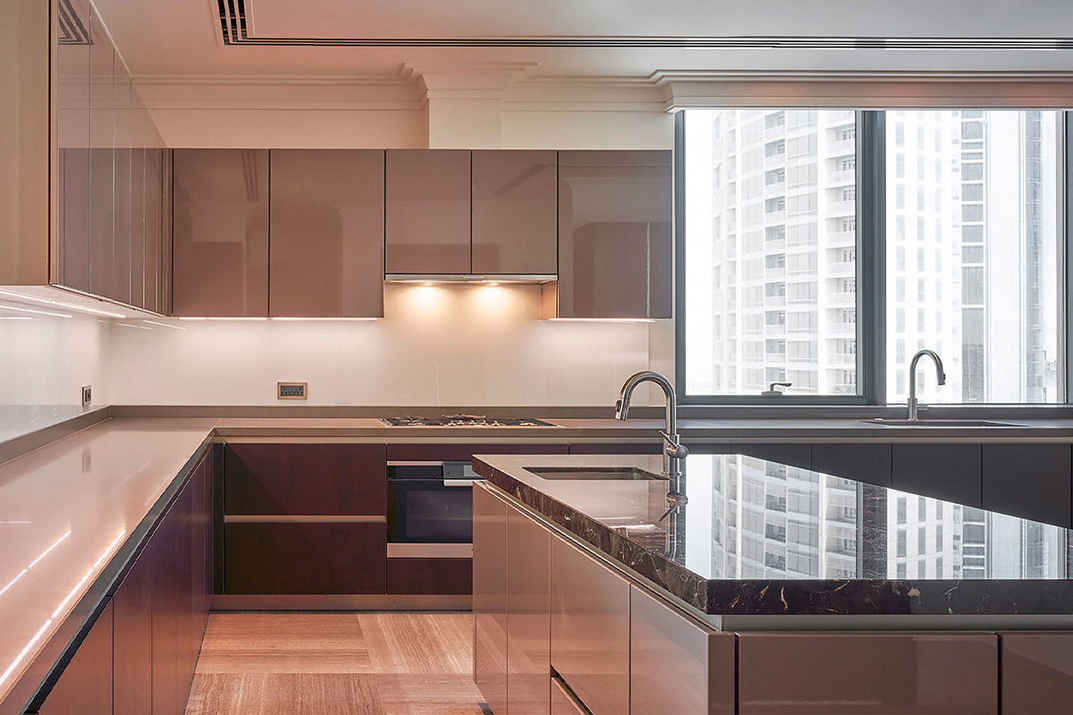 A neutral palette combining sterling grey and Walnut veneer. Minimalist kitchen design by SieMatic UAE.